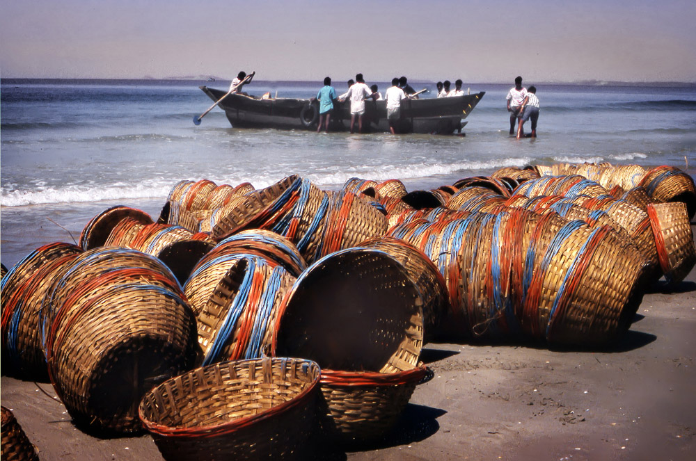 Pescatori Indiani si preparano ad uscire con le ceste colorate sulla spiaggia di Goa